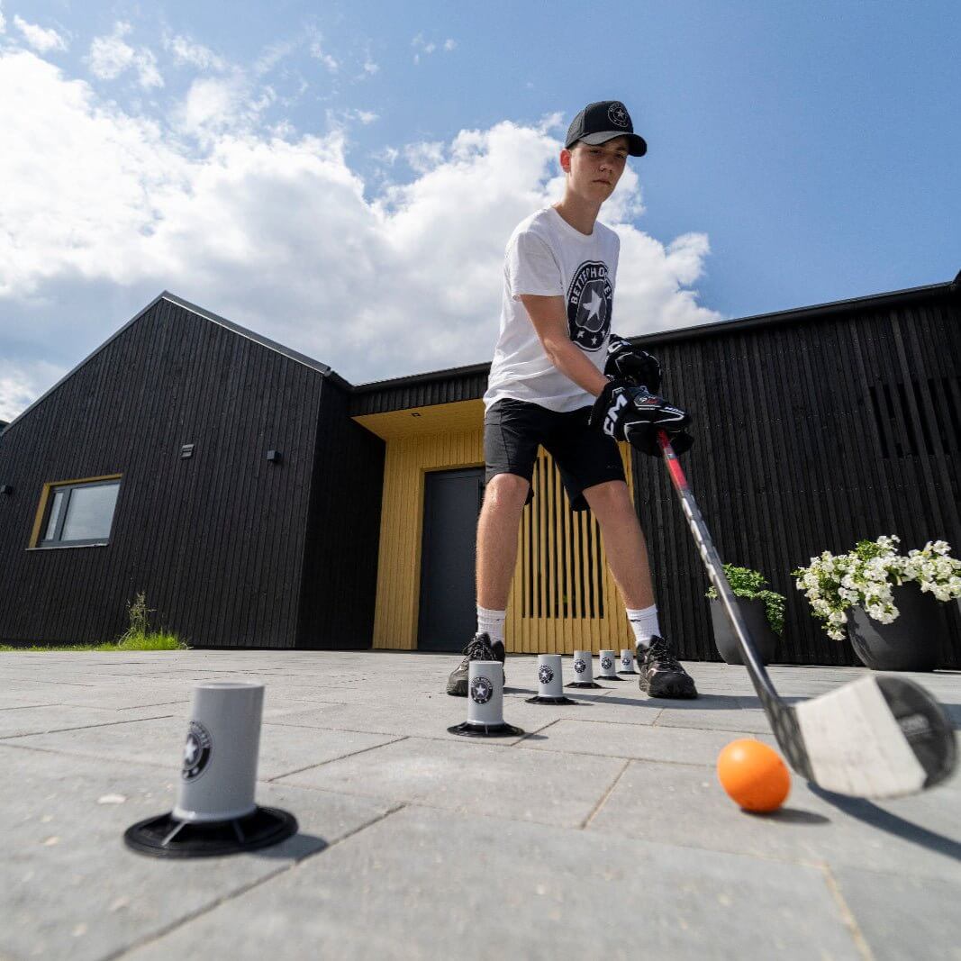 Young hockey player practicing skills with Extreme Drill Cones outdoors, focusing on technique and training efficiency.