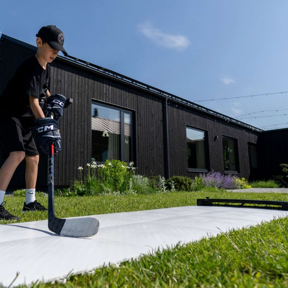 Barn spelar hockey på Plastis golvplattor utomhus, perfekt för träning och bygga skottramp.