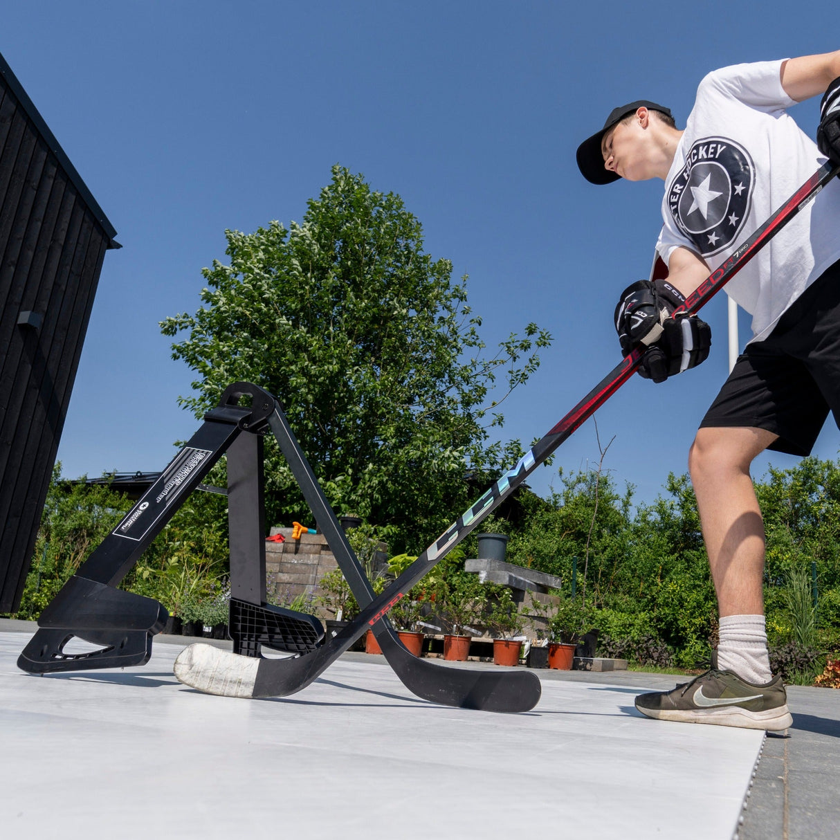 Ung kille tränar klubbteknik hockey med Extreme Pro Defender utomhus, fokuserar på smidiga rörelser.
