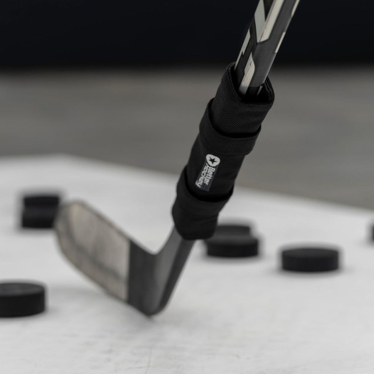 Pro kwaliteit klubbvikt hockey som förbättrar skottrörelser och handskicklighet, placerad på en isyta med puckar.