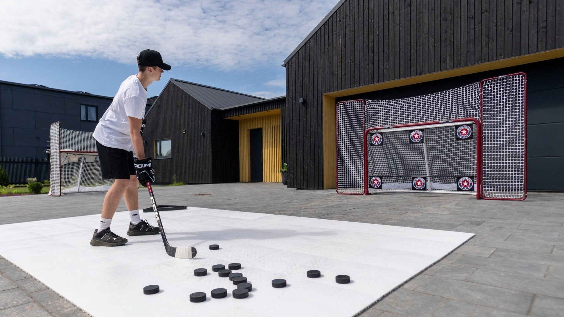 Två unga spelare i Better Hockey-kepsar framför hockeymålet