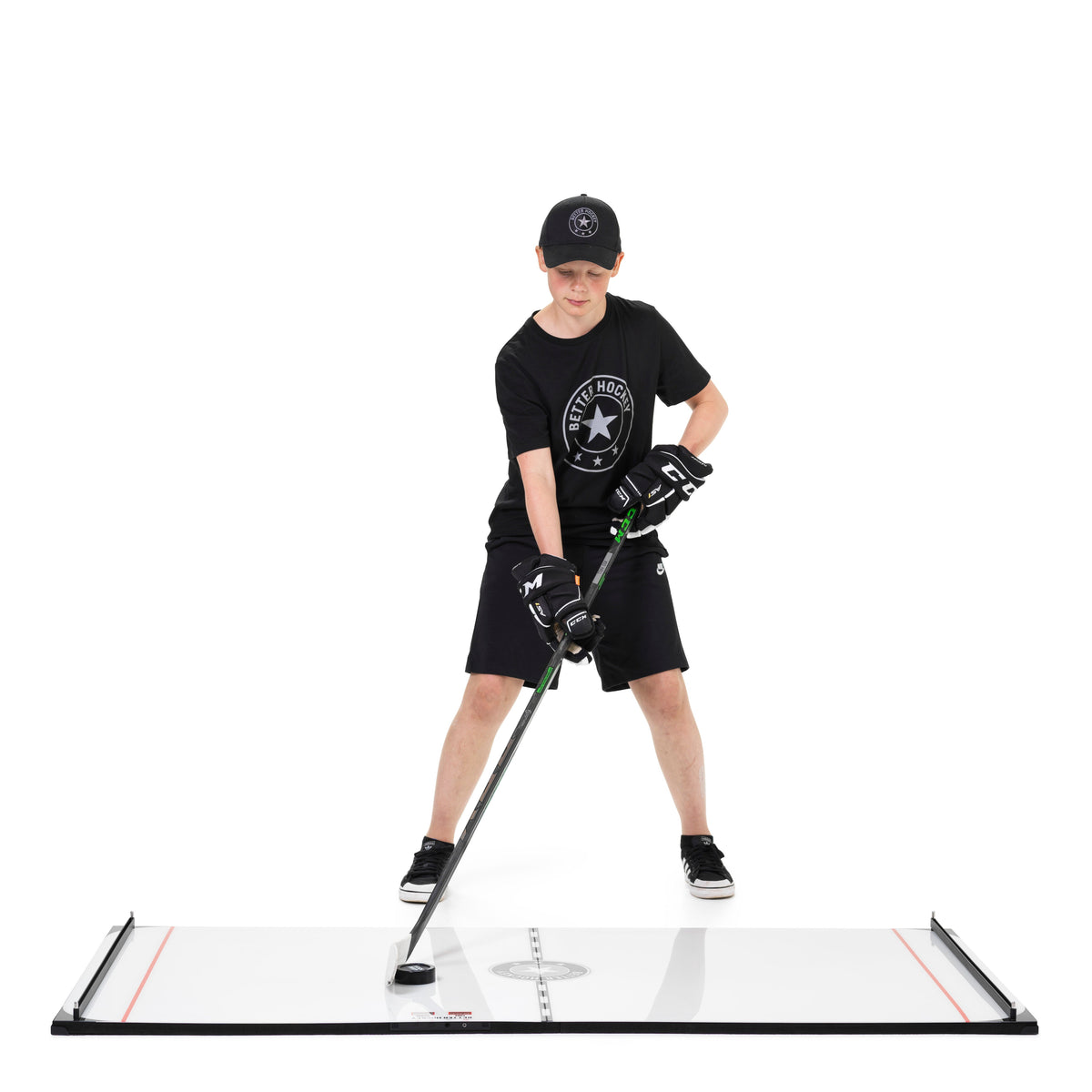 Hockey player running puck control drills on Better Hockey flooring tiles with training equipment set up outdoors