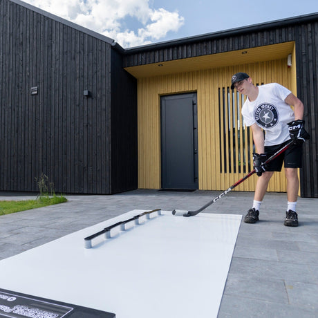 Young hockey player stickhandling on a training pad in the backyard, practicing between ice sessions