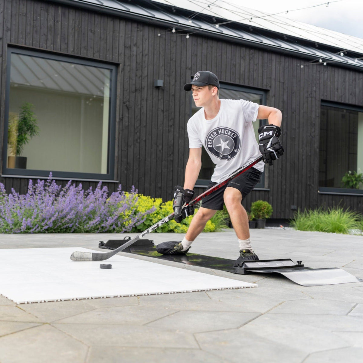 Hockey player training on slide board outdoors during off-season summer program