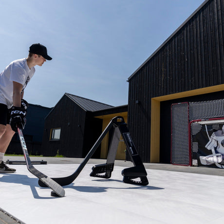 Hockey player working on puck handling around a Pro Defender in a driveway training session