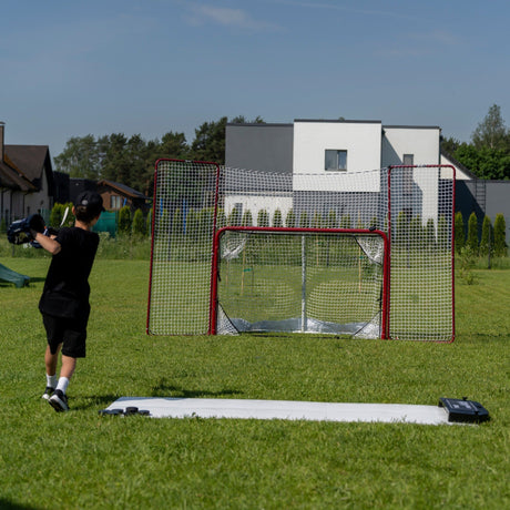 Young hockey player shooting on net outdoors using the Extreme Hockey Flooring Tiles Shooting Kit in a backyard setting
