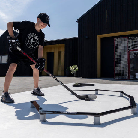 Young hockey player training outdoors with a stickhandling trainer, Better Hockey logo visible
