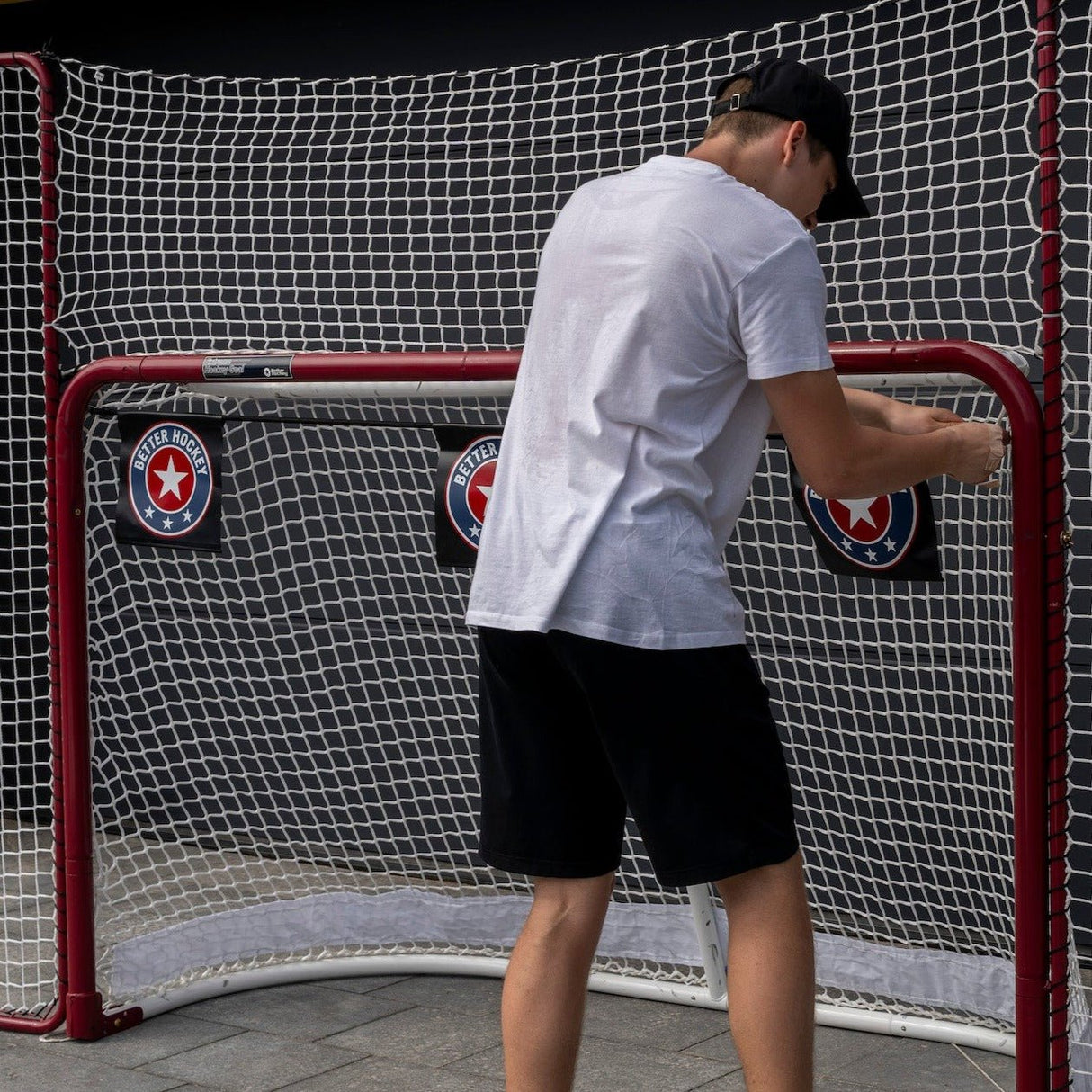 En spelare installerar skottavlor i en hockeymål som förbättrar träffsäkerheten vid skotträning.