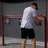 En spelare installerar skottavlor i en hockeymål som förbättrar träffsäkerheten vid skotträning.