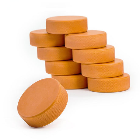 Tunga puckar i orange, perfekt för on & off-ice träning, ökar skottstyrka och teknik för hockeyspelare.