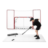 Ung kille som skjuter puckar mot redskap på hockeygolv, omgiven av målvaktsnät för träning på Extreme Hockey Flooring.