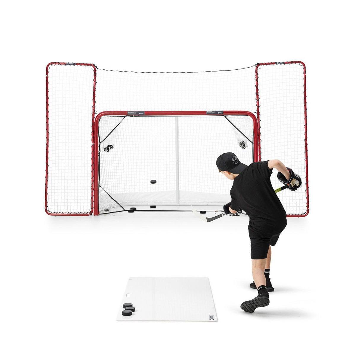 En spelare skjuter puckar mot ett mål med en skottplatta hockey, perfekt för träning och spelutveckling.