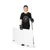 Ung hockeyspelare med skottramp står med klubba, klädd i sportig t-shirt och handskar för träning.