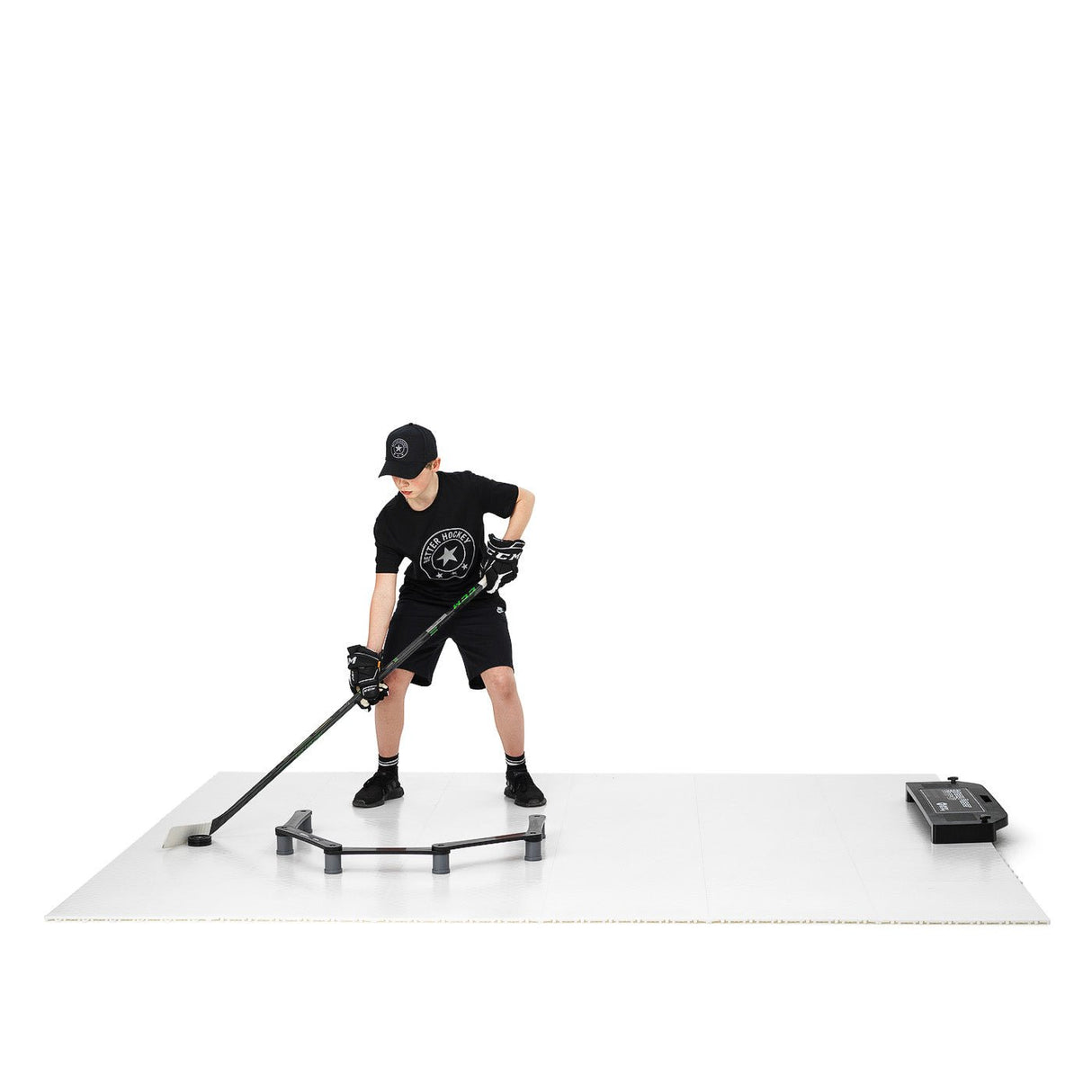 Ung spelare använder Extreme Hockey teknikpaket för att öva passningar och skott på en skottramp hemma.